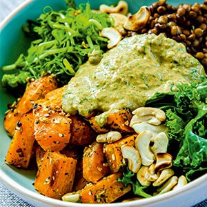 Lęšių ir saldžiųjų bulvių Buddha Bowl su kale kopūstais ir žemės riešutų padažu